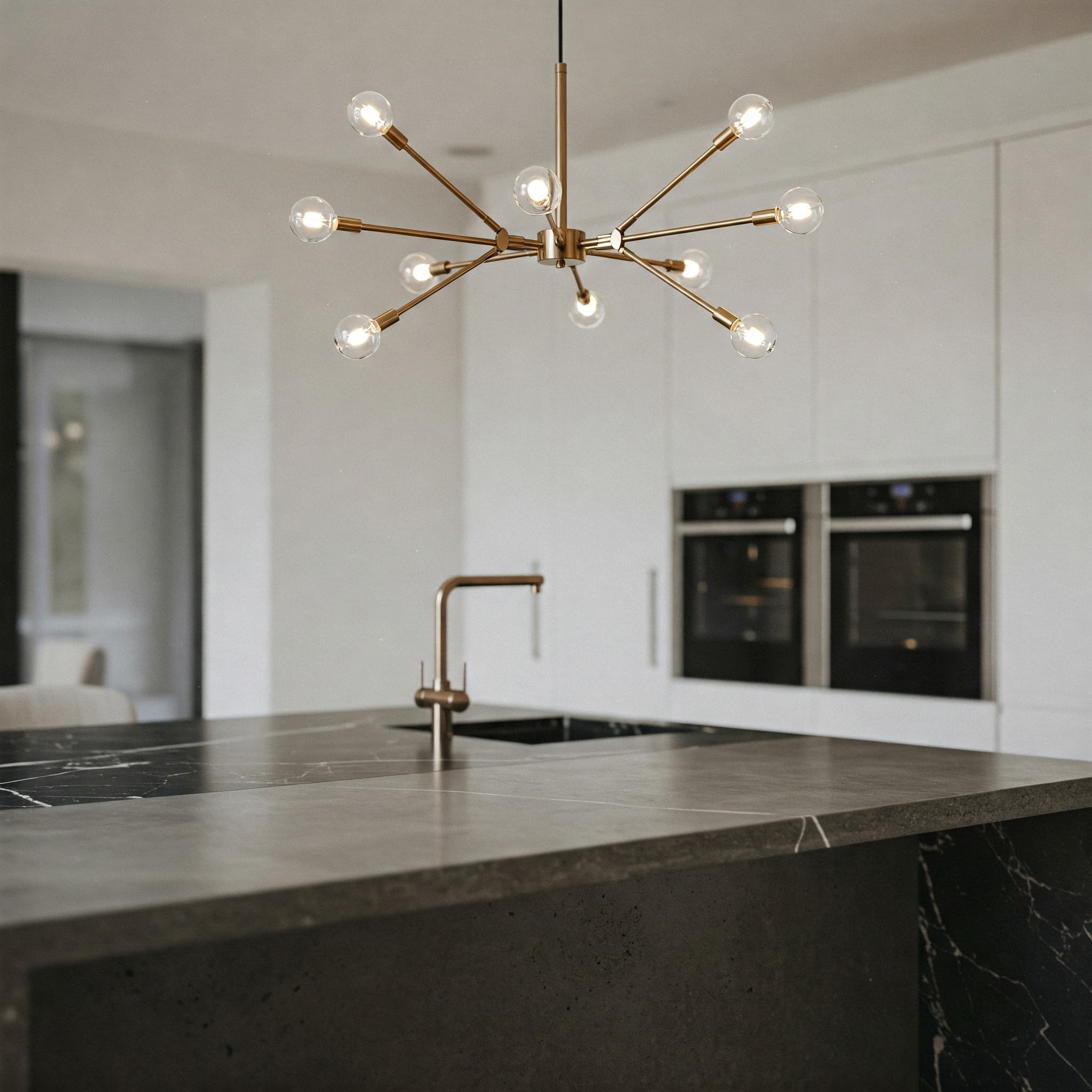 Modern kitchen island featuring a stylish chandelier as a central lighting fixture.