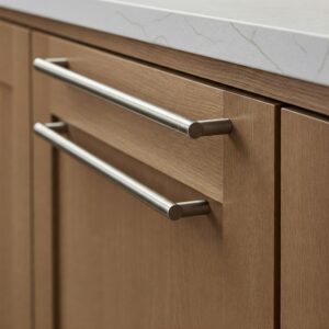 Detailed view of elegant hardware on light brown kitchen cabinets.