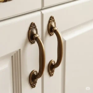 "Close-up of stylish bronze cabinet pulls on white kitchen cabinetry, highlighting their intricate design and rich finish, perfect for traditional or transitional kitchens."