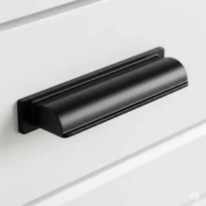 "Close-up of a minimalist matte black kitchen hardware cabinet pull on a white kitchen cupboard, highlighting its smooth finish."