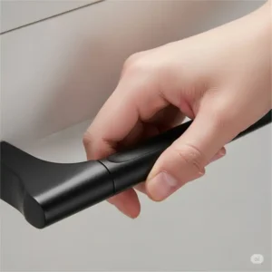 Hand gripping a black kitchen cabinet pulls, highlighting its ergonomic design and comfortable feel.