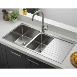  Double bowl kitchen sink with drainboard, offering versatile washing and drying space.
