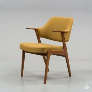 Sleek mid-century modern vintage kitchen chair with clean lines and an ergonomic design, upholstered in a muted mustard fabric.
