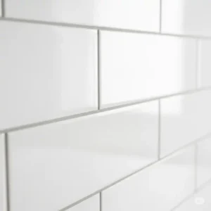 Detailed shot focusing on the pristine white grout lines of a white on white kitchen backsplash, emphasizing neatness and precision.