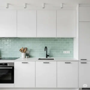 Sleek modern kitchen with a minimalist light green backsplash kitchen, contrasting with black kitchen fixtures.