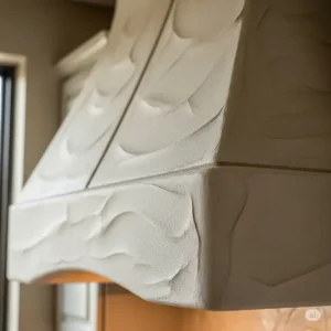 A close-up view of the smooth, textured finish on a custom-built plaster kitchen hood.