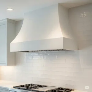 A beautiful white plaster kitchen hood that complements a light-colored kitchen backsplash.