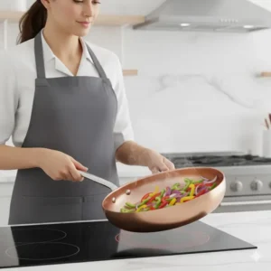 Image showing a chef using a Copper induction pan to sauté vegetables on an induction stove.