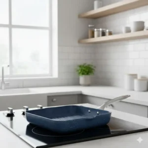 A stylish blue ceramic grill pan placed on a modern stove in a bright kitchen.